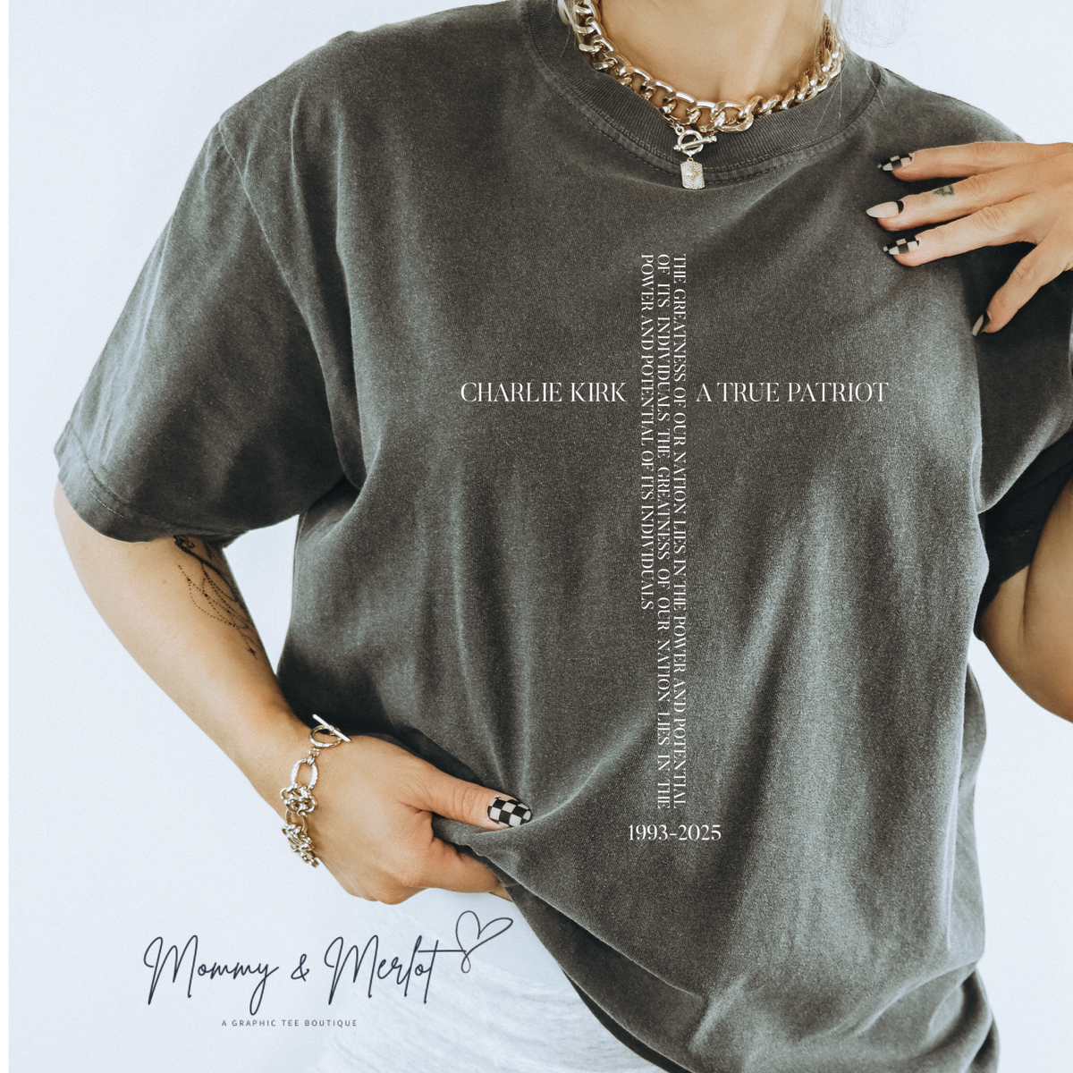Person wearing a gray t-shirt with text and branding on a light gray background